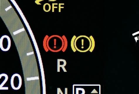 Automobilio prietaisų skydelis su užsidegusiu raudonu trikampiu įspėjamuoju ženklu