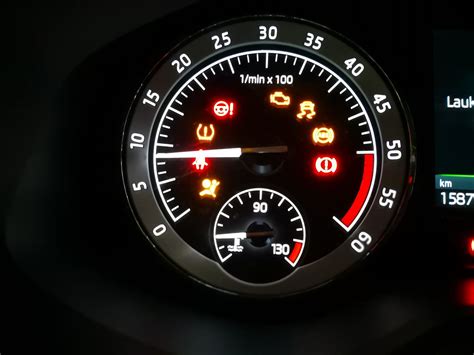 Scheminis automobilio prietaisų skydelis su akcentuota padangų slėgio indikatoriaus lempute.