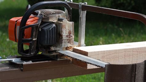 ugniagesiai dirba su grandininiu pjūklu prie išversto medžio