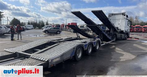 Nuotrauka, iliustruojanti automobilio pakrovimą ant priekabos naudojant gervę