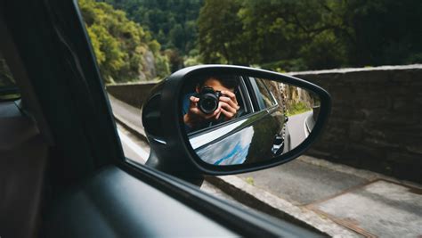 Teminė nuotrauka: žmogus apžiūri automobilį ir fotografuoja defektus prieš nuomą