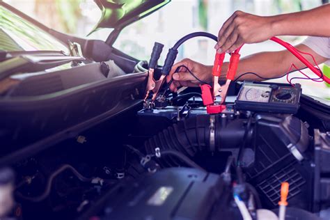 Schematinis akumuliatoriaus prijungimo prie kito automobilio vaizdas, iliustruojantis 