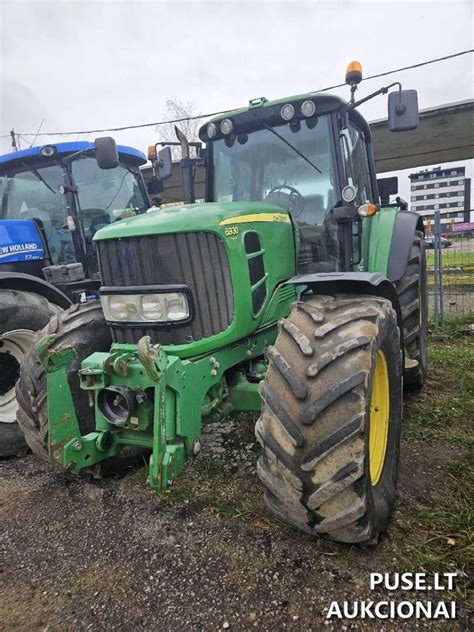 Teminė nuotrauka su John Deere traktoriumi ir jo pavarų dėže