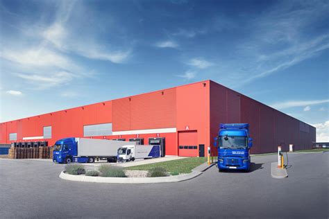 Elektrinių vilkikų įkrovimo stotelės ir sunkvežimių parko iliustracija
