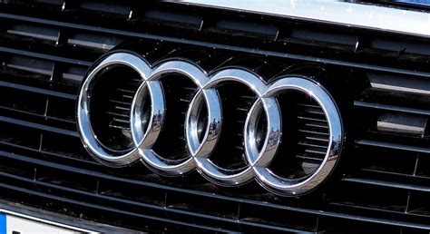Audi logotipas su keturiais žiedais ir keliais Audi modeliais