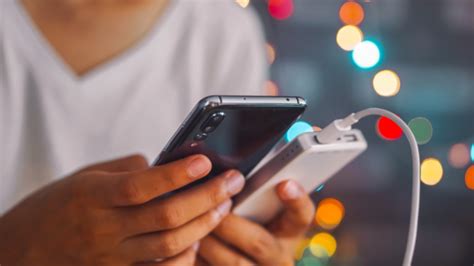 Tematinė nuotrauka: žmogus, tikrinantis telefono baterijos būseną