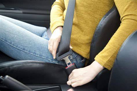 Tematinė nuotrauka: saugos diržą segantis žmogus automobilyje