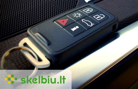 Nuotrauka, vaizduojanti meistrą, dirbantį su Volvo raktu ir specializuota programavimo įranga.