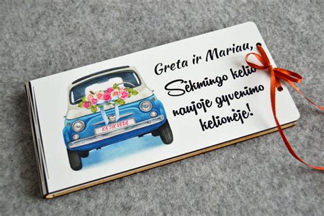 Klasikinis vestuvinis automobilis, dekoruotas švelnių tonų gėlėmis ir juostomis