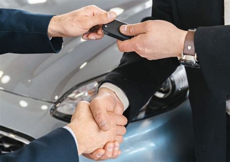 Tematinė nuotrauka: Rankos laiko sutartį su automobilio raktais, simbolizuojant pratęstą garantiją.