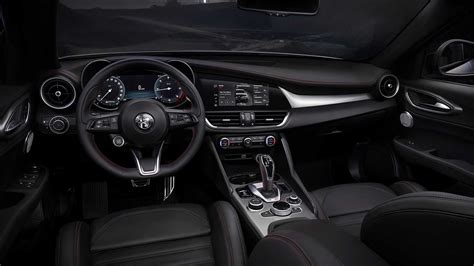 Nuotrauka, demonstruojanti Alfa Romeo Giulia interjero dizainą su apvaliais elementais ir dideliu ekranu.