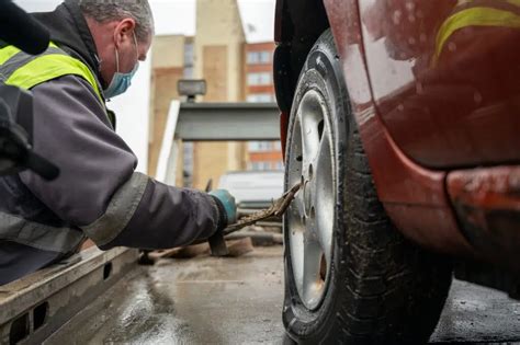 darbuotojas ant pastolių automobilių servise