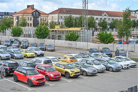 Teminė nuotrauka: automobilių aikštelė su įvairiais naudotais automobiliais saulėtą dieną, rodanti didelį pasirinkimą