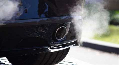 Tematinė nuotrauka: galinis automobilio vaizdas su išmetimo vamzdžiu ir dūmais