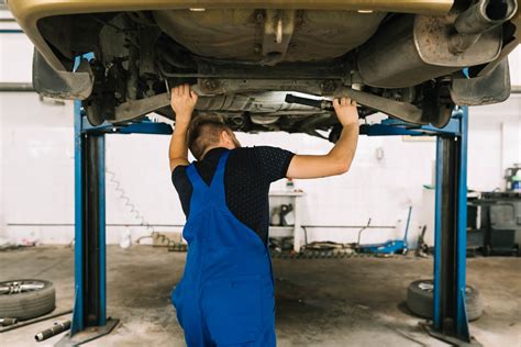 Automechanikas tikrina automobilio pakabą ant keltuvo