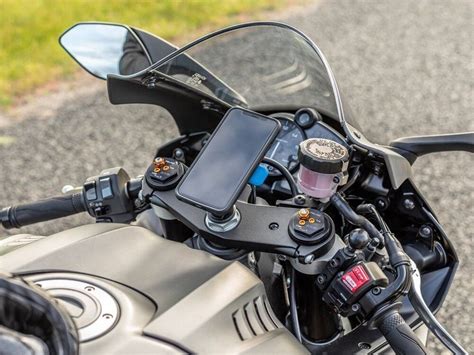iliustracija, demonstruojanti reguliuojamo deflektoriaus montavimą ant motociklo stiklo