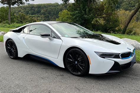 BMW i8 Coupe ir Roadster modelių palyginimas, pabrėžiant dureles ir stogą