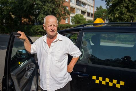 Laimingas taksi vairuotojas, skaičiuojantis uždarbį
