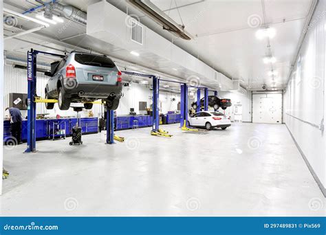 Interior shot of a car service bay with a mechanic working on a car