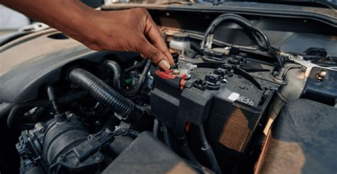 mechanikas tikrina automobilio apiplovimo siurblio kontaktus multimetru