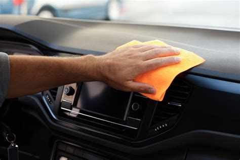 Nuotrauka, vaizduojanti automobilio salono valymą ir dėmesį prietaisų skydeliui bei vidiniam stiklui.