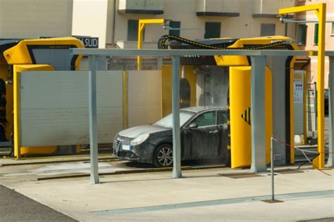 Iliustracija, vaizduojanti įvairias transporto priemones (automobilius, laivus, lėktuvus), laukiančias eilėje prie modernios automobilių plovyklos.