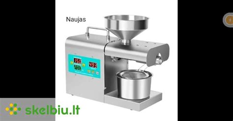 Nuotrauka, vaizduojanti šalto spaudimo aliejaus presą virtuvėje su skirtingomis sėklomis ir šviežiai išspaustu aliejumi