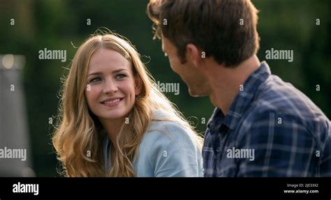Scott Eastwood ir Britt Robertson romantiškoje scenoje, vakarieniaujant lauke.
