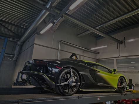 Teminė iliustracija: modernus automobilių servisas ir kvalifikuoti mechanikai atliekantys diagnostiką