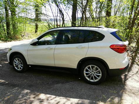Nuotrauka, vaizduojanti naujo akumuliatoriaus įdėjimą į BMW X1 F48
