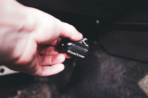 specialistas programuojantis raktą prie automobilio valdymo bloko