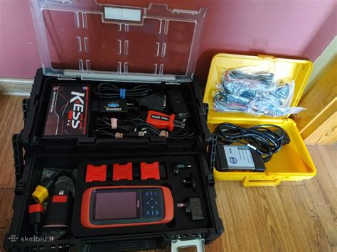 Profesionalus autoelektrikas dirba su diagnostikos įranga prie automobilio variklio skyriaus