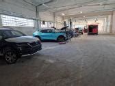 Automobilių remonto dirbtuvių vizualizacija, rodanti kėbulų dažymo ir techninės priežiūros procesus.
