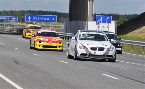 Automobilių sporto renginio akimirka, simbolizuojanti klubo veiklą lenktynių trasose