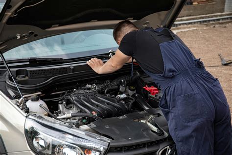 Automobilių serviso interjeras Skriaudžiuose, mechanikai dirba su automobiliais