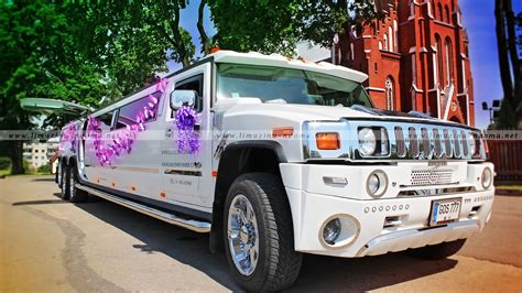 Nuotrauka baltos spalvos Hummer limuzino vestuvių fone