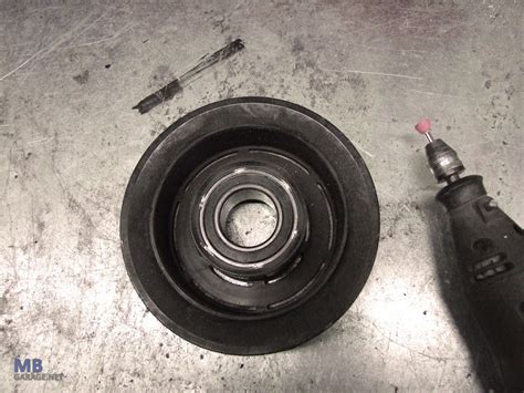 detali schematinė iliustracija, kaip nuimti ir pakeisti automobilio kondicionieriaus kompresoriaus sankabos skriemulio guolį