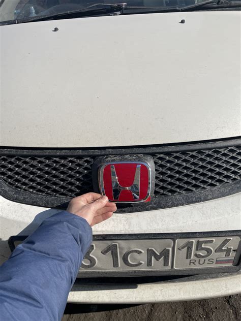Фотография установленной красной эмблемы Honda на автомобиле