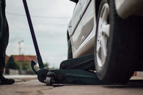 Detali infografika, rodanti teisingą domkrato padėtį po automobiliu ir kėlimo taškus