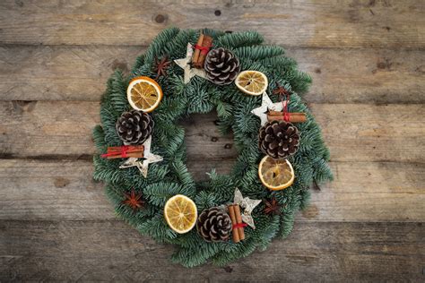 Kalėdinis vainikas, papuoštas kankorėžiais ir cinamono lazdelėmis