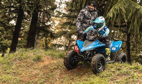Paauglys ant 125cc benzininio keturračio, pasiruošęs važiuoti