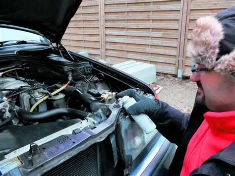 Tematinė nuotrauka: stovintis automobilis su atidarytu variklio dangčiu, užšalęs automobilis žiemos fone