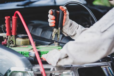 Tematinė nuotrauka: vairuotojas krauna automobilio akumuliatorių
