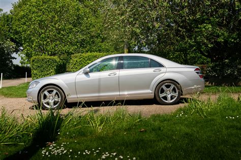 Nuotrauka, vaizduojanti prabangų Mercedes-Benz W221 S320 CDI saloną su medžio intarpais ir odinėmis sėdynėmis