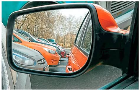 Tematinė nuotrauka: vairuotojas reguliuoja automobilio veidrodėlius