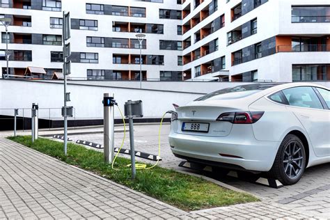 Vaizdinis elementas: modernus elektromobilis, važiuojantis miesto gatve