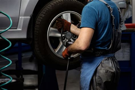 Teminė nuotrauka su mechaniku, bendraujančiu su klientu autoservise
