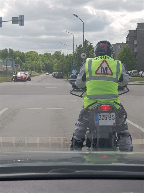 Vairavimo mokyklos motociklų mokymo aikštelė su mokiniais ir instruktoriumi