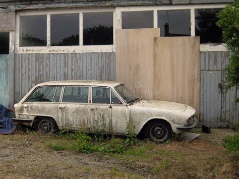 Thematic photo of an old, somewhat dilapidated car in a yard or garage