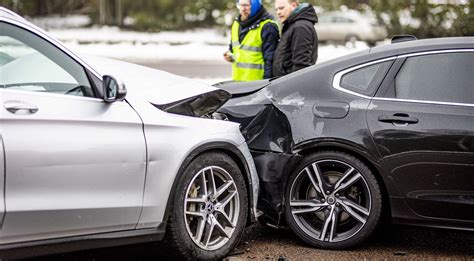 Ekspertas apžiūri apgadintą automobilį po avarijos